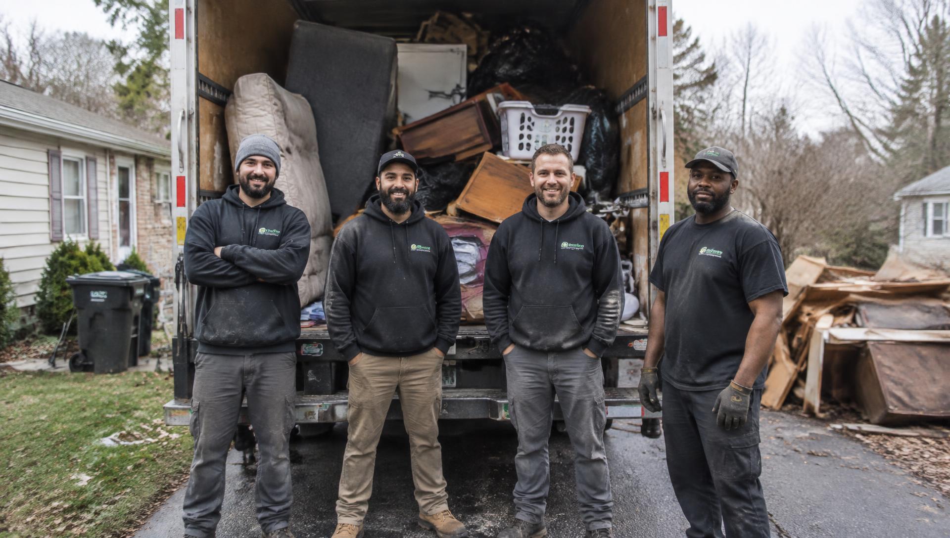 The Summit Haul crew in front of a loaded junk removal truck